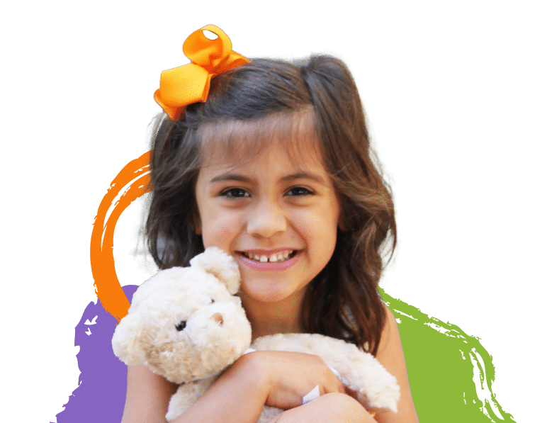 A happy little girl holding a stuffed teddy bear