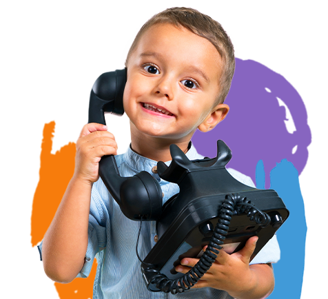 A little boy holding a telephone making a silly face