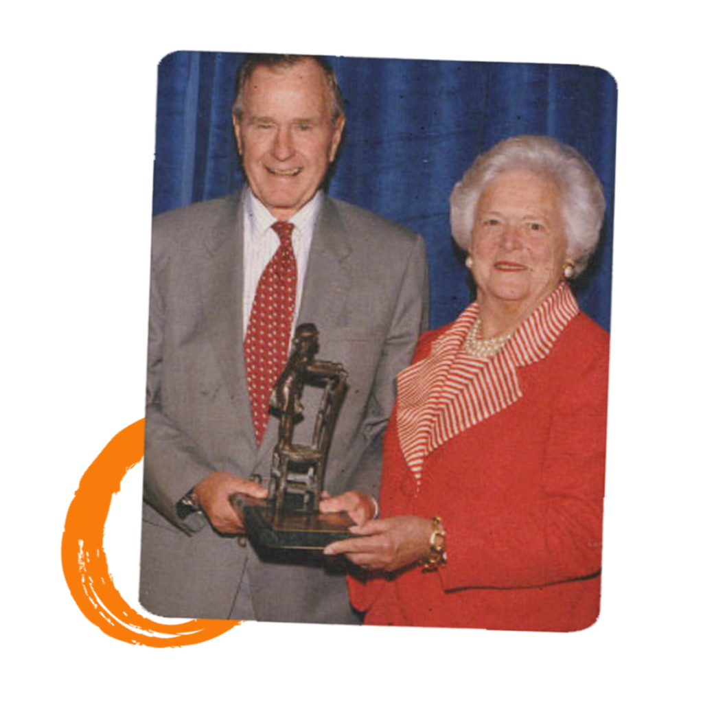 President George H. W. Bush and First Lady Barbara Bush holding an award