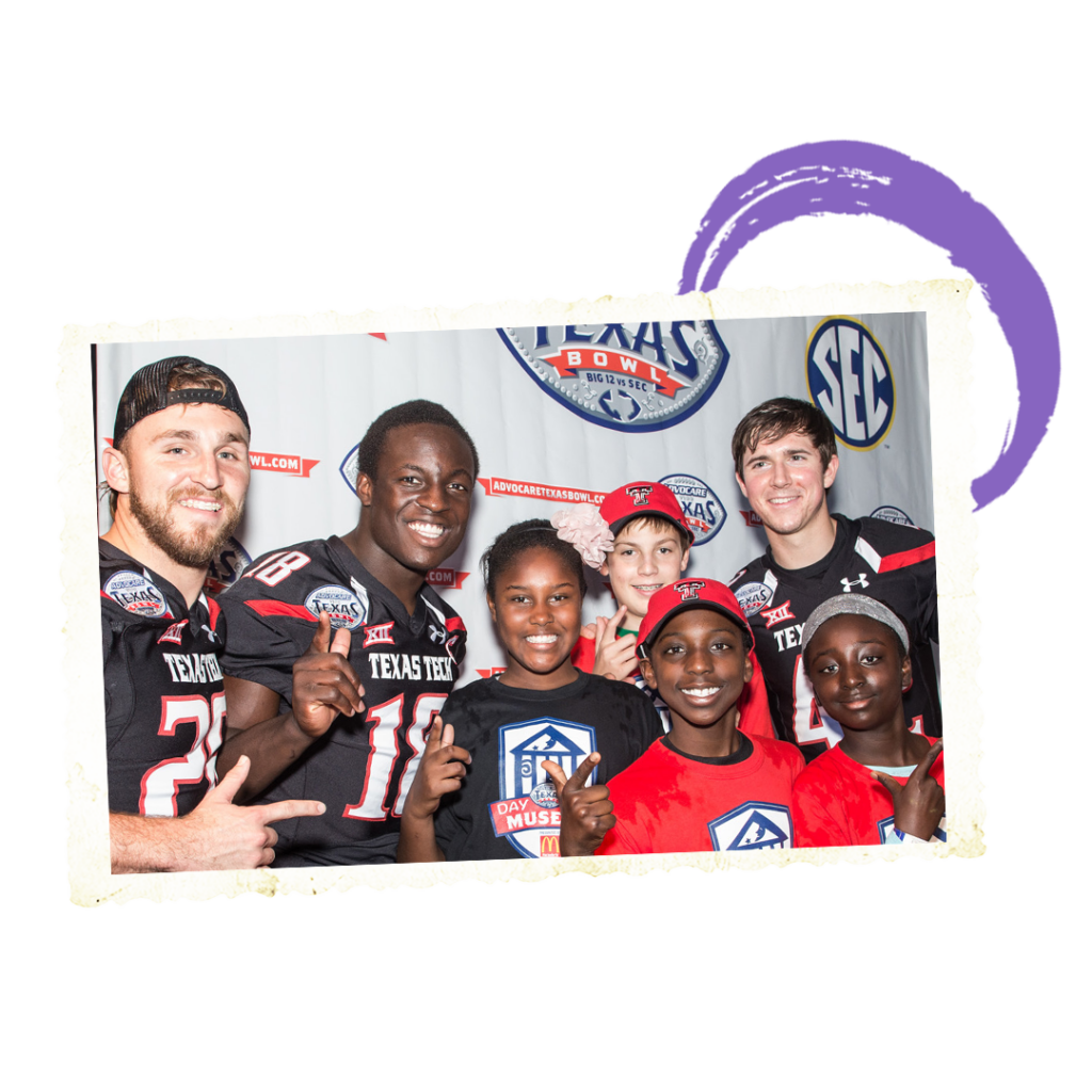 Football players posing with kids