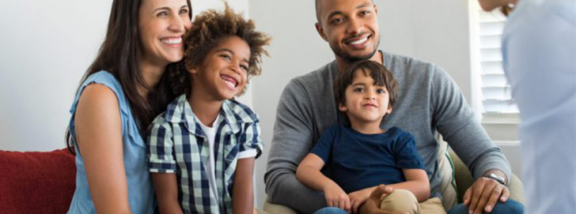 A couple with their adopted sons talking to a counselor