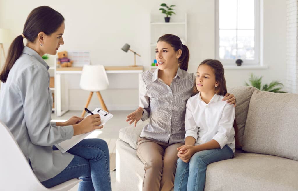 A lady and her daughter talking to a counselor