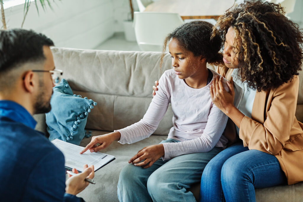 A lady and her daughter talking to a counselor