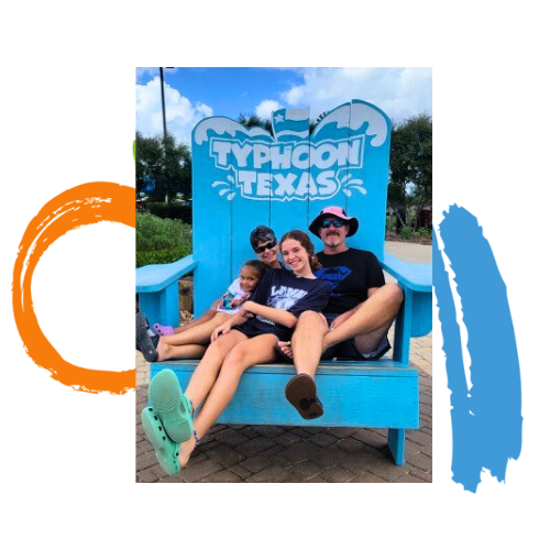 A family sitting in an oversized chair at Typhoon Texas