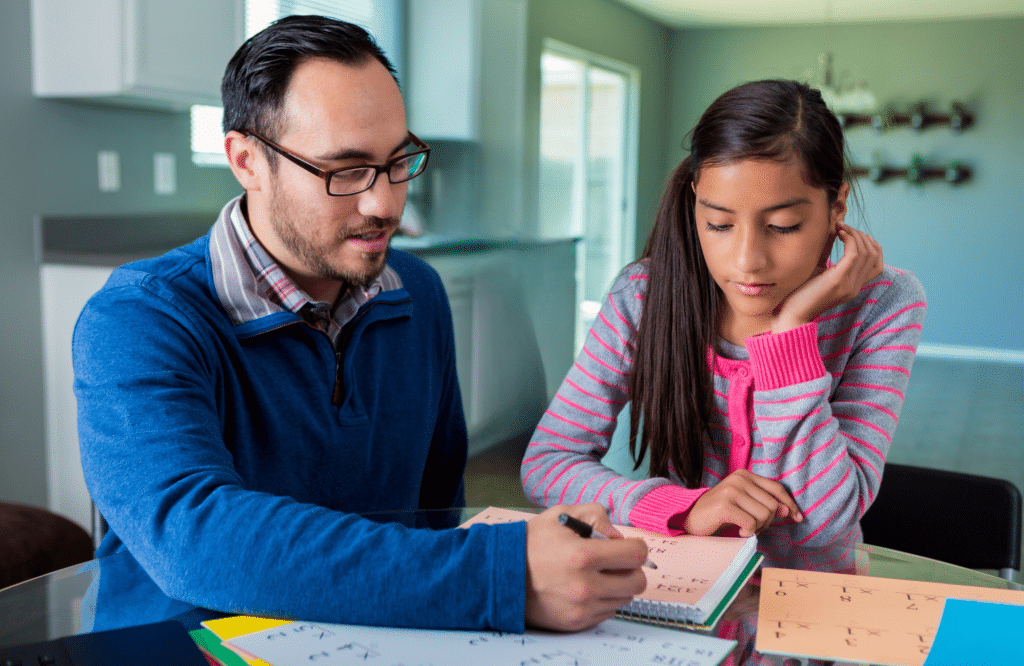 A man helping his daughter with her homework