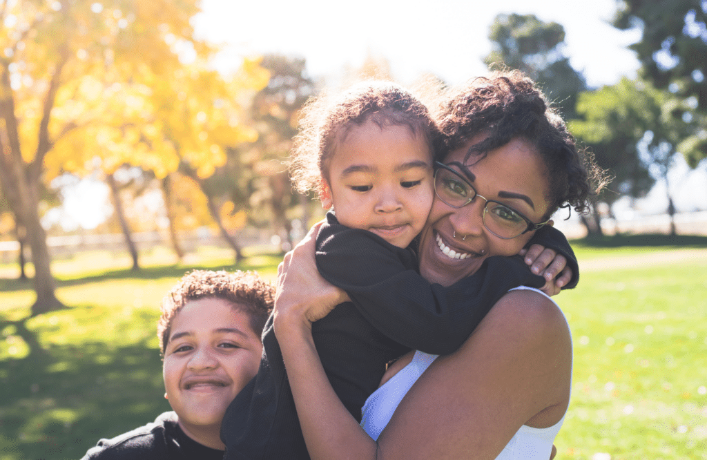 A lady hugging her two kids