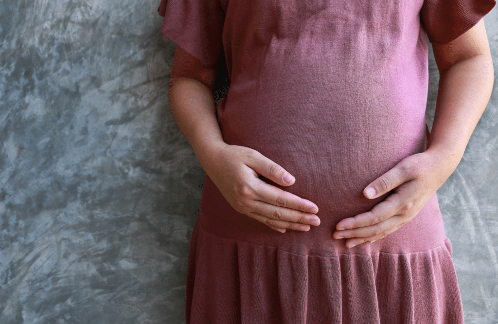 A pregnant lady holding her belly