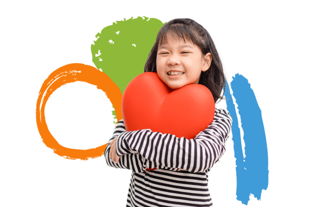 A little girl hugging a large plastic heart